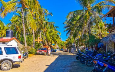 Puerto Escondido Oaxaca Meksika 27. Ocak 2023 İnsanların bulunduğu tipik renkli turist caddesi Zicatela Puerto Escondido Oaxaca Meksika 'daki La Punta' da restoran dükkanları, arabalar ve bar..