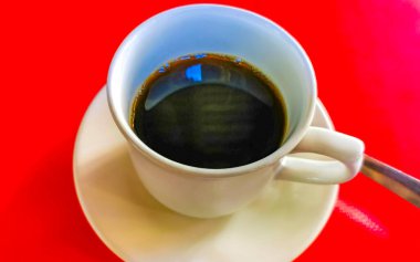 Zicatela Puerto Escondido Oaxaca Meksika 'daki restoranda bir fincan siyah kaşık ve tabak kırmızı masa arkası yiyecek ve içecek..