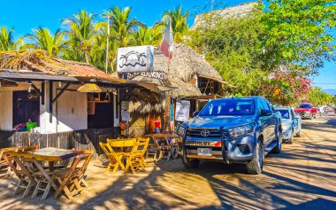 Puerto Escondido Oaxaca Meksika 27. Ocak 2023 İnsanların bulunduğu tipik renkli turist caddesi Zicatela Puerto Escondido Oaxaca Meksika 'daki La Punta' da restoran dükkanları, arabalar ve bar..