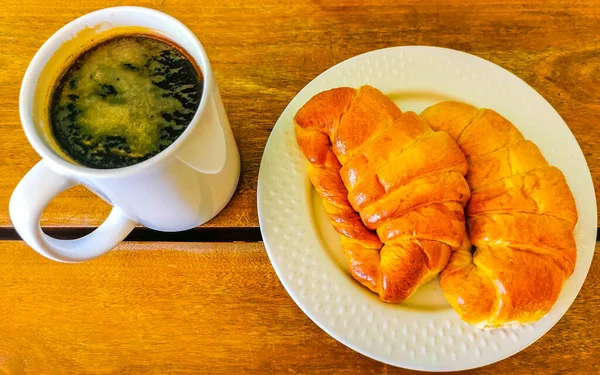 墨西哥埃斯坎多瓦哈卡港 Zicatela Puerto Escondido Oaxaca 的木桌上有咖啡和羊角的典型法国早餐 — 图库照片