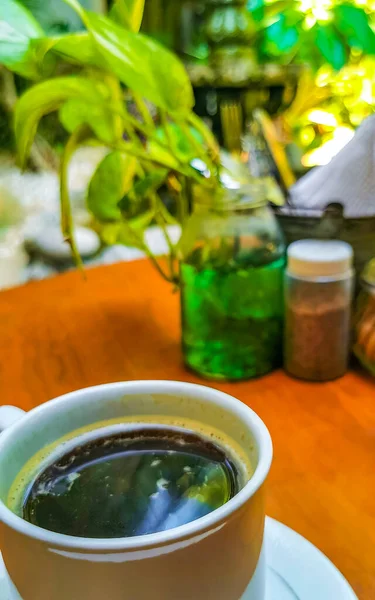 テーブルの上にスプーンとプレートとアメリカーノブラックコーヒーのカップとZicatelaプエルトエスコンディドオアハカメキシコのレストランで飲む — ストック写真