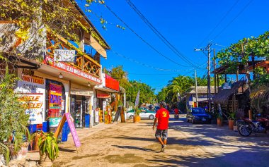 Puerto Escondido Oaxaca Meksika 27. Ocak 2023 İnsanların bulunduğu tipik renkli turist caddesi Zicatela Puerto Escondido Oaxaca Meksika 'daki La Punta' da restoran dükkanları, arabalar ve bar..