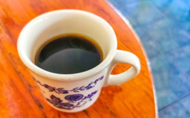Zicatela Puerto Escondido Mexico 'daki El Cafecito' daki ahşap masada siyah kahve fincanı..