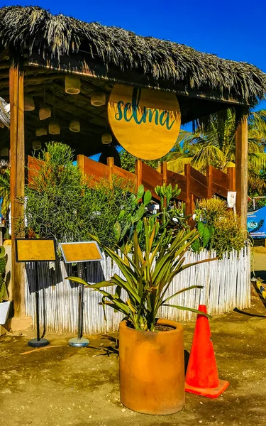 stock image Puerto Escondido Oaxaca Mexico 27. January 2023 Typical colorful tourist street with people tourist shops stores restaurants cars and bar in La Punta in Zicatela Puerto Escondido Oaxaca Mexico.