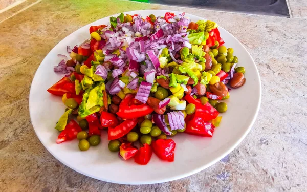 豆と野菜ビーガン料理エンドウ豆のジャガイモ玉ねぎのトマトとメキシコのフォークやスプーンとホワイトプレートのボウルにニンニク — ストック写真