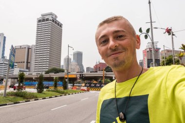 Turist gezgini, Kuala Lumpur Malezya, Güneydoğu Asya 'daki şehir manzarası binaları ve gökdelenlerle selfie çekiyor..