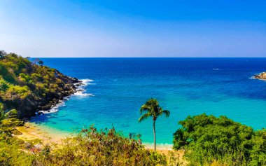 Kumsal turkuvaz mavi su kayaları kaya kayaları palmiye ağaçları büyük sörfçü dalgaları ve Puerto Escondido Oaxaca 'daki Playa Carrizalillo plajı manzarası.