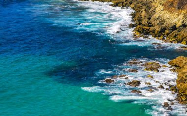 Kumsal turkuvaz mavi su kayaları kaya kayaları palmiye ağaçları büyük sörfçü dalgaları ve Puerto Escondido Oaxaca 'daki Playa Carrizalillo plajı manzarası.