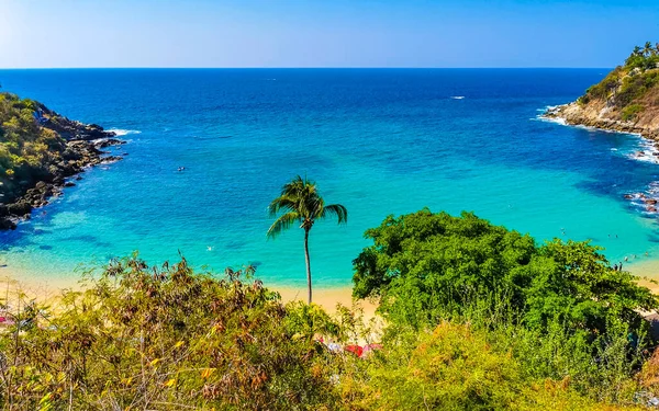 Kumsal turkuvaz mavi su kayaları kaya kayaları palmiye ağaçları büyük sörfçü dalgaları ve Puerto Escondido Oaxaca 'daki Playa Carrizalillo plajı manzarası.