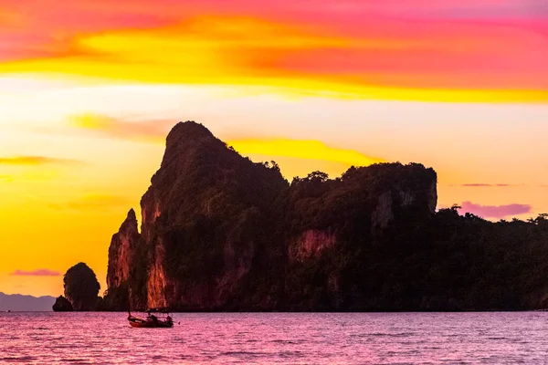 Amphoe Mueang Krabi Tayland ve Güneydoğu Asya 'daki Koh Phi Phi Don Adası' ndaki muhteşem kireçtaşı kayaları arasındaki plajda nefis ve göz kamaştırıcı bir altın gün batımı ve tropikal cennet manzarası..