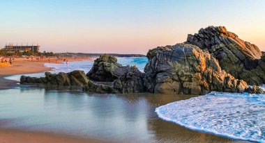 Mavi turkuaz su ve son derece güzel büyük sörfçü kayalıkları kayalar dağlar ve kayalar Zicatela Puerto Escondido Oaxaca 'daki plajlar.