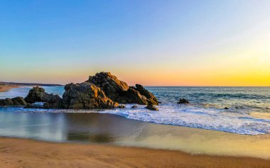 Mavi turkuaz su ve son derece güzel büyük sörfçü kayalıkları kayalar dağlar ve kayalar Zicatela Puerto Escondido Oaxaca 'daki plajlar.