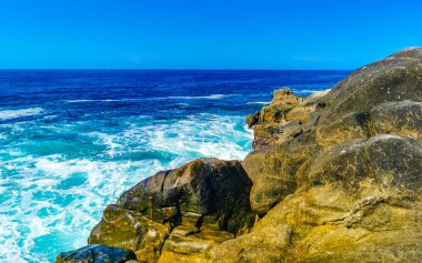 Mavi turkuaz su ve son derece güzel büyük sörfçü kayalıkları kayalar dağlar ve kayalar Zicatela Puerto Escondido Oaxaca 'daki plajlar.