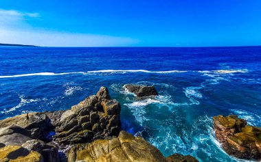 Mavi turkuaz su ve son derece güzel büyük sörfçü kayalıkları kayalar dağlar ve kayalar Zicatela Puerto Escondido Oaxaca 'daki plajlar.
