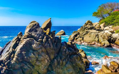 Mavi turkuaz su ve son derece güzel büyük sörfçü kayalıkları kayalar dağlar ve kayalar Zicatela Puerto Escondido Oaxaca 'daki plajlar.