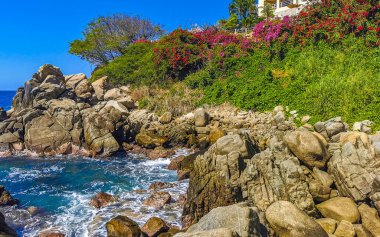 Mavi turkuaz su ve son derece güzel büyük sörfçü kayalıkları kayalar dağlar ve kayalar Zicatela Puerto Escondido Oaxaca 'daki plajlar.
