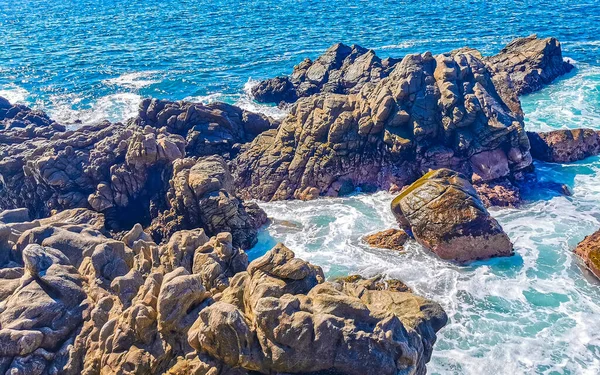 Mavi turkuaz su ve son derece güzel büyük sörfçü kayalıkları kayalar dağlar ve kayalar Zicatela Puerto Escondido Oaxaca 'daki plajlar.