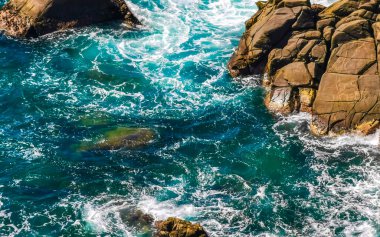 Mavi turkuaz su ve son derece güzel büyük sörfçü kayalıkları kayalar dağlar ve kayalar Zicatela Puerto Escondido Oaxaca 'daki plajlar.