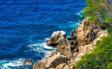 Mavi turkuaz su ve son derece güzel büyük sörfçü kayalıkları kayalar dağlar ve kayalar Zicatela Puerto Escondido Oaxaca 'daki plajlar.