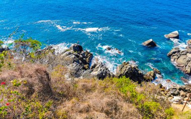 Mavi turkuaz su ve son derece güzel büyük sörfçü kayalıkları kayalar dağlar ve kayalar Zicatela Puerto Escondido Oaxaca 'daki plajlar.