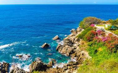 Mavi turkuaz su ve son derece güzel büyük sörfçü kayalıkları kayalar dağlar ve kayalar Zicatela Puerto Escondido Oaxaca 'daki plajlar.