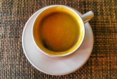 Glass cup of americano black coffee with spoon and plate on table food and drink in the restaurant PapaCharly Papa Charly in Playa del Carmen Quintana Roo Mexico.