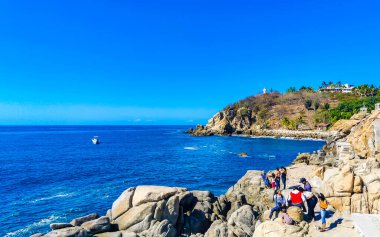 Puerto Escondido Oaxaca Meksika 25. Mart 2023 Mavi turkuaz su ve son derece güzel büyük sörfçü kayalıkları kayalar dağları kayalar Puerto Escondido Meksika sahillerinde kayalar.