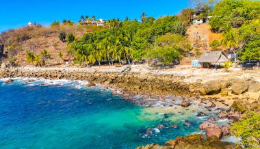 Mavi turkuaz su ve son derece güzel büyük sörfçü kayalıkları kayalar dağlar ve kayalar Zicatela Puerto Escondido Oaxaca 'daki plajlar.