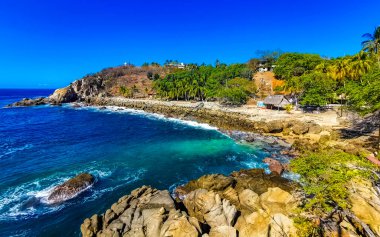 Mavi turkuaz su ve son derece güzel büyük sörfçü kayalıkları kayalar dağlar ve kayalar Zicatela Puerto Escondido Oaxaca 'daki plajlar.