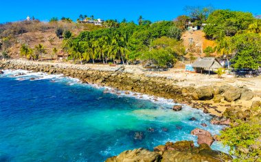 Mavi turkuaz su ve son derece güzel büyük sörfçü kayalıkları kayalar dağlar ve kayalar Zicatela Puerto Escondido Oaxaca 'daki plajlar.