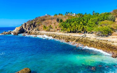 Mavi turkuaz su ve son derece güzel büyük sörfçü kayalıkları kayalar dağlar ve kayalar Zicatela Puerto Escondido Oaxaca 'daki plajlar.