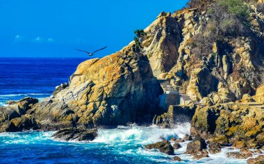 Mavi turkuaz su ve son derece güzel büyük sörfçü kayalıkları kayalar dağlar ve kayalar Zicatela Puerto Escondido Oaxaca 'daki plajlar.