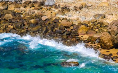 Mavi turkuaz su ve son derece güzel büyük sörfçü kayalıkları kayalar dağlar ve kayalar Zicatela Puerto Escondido Oaxaca 'daki plajlar.