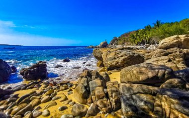 Mavi turkuaz su ve son derece güzel büyük sörfçü kayalıkları kayalar dağlar ve kayalar Zicatela Puerto Escondido Oaxaca 'daki plajlar.