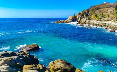 Mavi turkuaz su ve son derece güzel büyük sörfçü kayalıkları kayalar dağlar ve kayalar Zicatela Puerto Escondido Oaxaca 'daki plajlar.