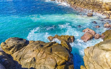 Mavi turkuaz su ve son derece güzel büyük sörfçü kayalıkları kayalar dağlar ve kayalar Zicatela Puerto Escondido Oaxaca 'daki plajlar.