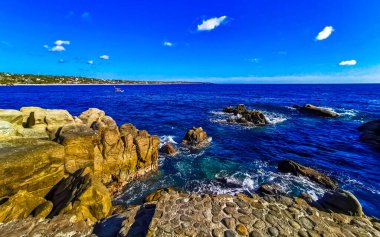 Mavi turkuaz su ve son derece güzel büyük sörfçü kayalıkları kayalar dağlar ve kayalar Zicatela Puerto Escondido Oaxaca 'daki plajlar.