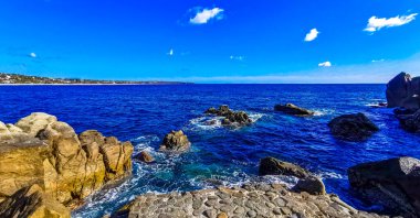 Mavi turkuaz su ve son derece güzel büyük sörfçü kayalıkları kayalar dağlar ve kayalar Zicatela Puerto Escondido Oaxaca 'daki plajlar.