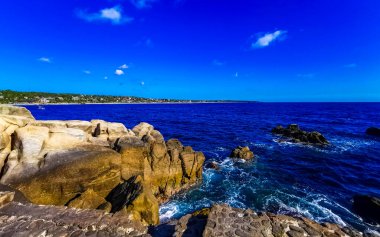 Mavi turkuaz su ve son derece güzel büyük sörfçü kayalıkları kayalar dağlar ve kayalar Zicatela Puerto Escondido Oaxaca 'daki plajlar.