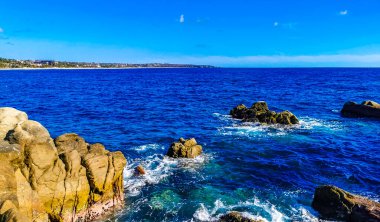 Mavi turkuaz su ve son derece güzel büyük sörfçü kayalıkları kayalar dağlar ve kayalar Zicatela Puerto Escondido Oaxaca 'daki plajlar.