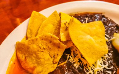 Meksika omleti ve siyah fasulyeli yumurta patates ve beyaz tabakta nachos Zicatela Puerto Oaxaca Meksika 'da El Cafecito' da..