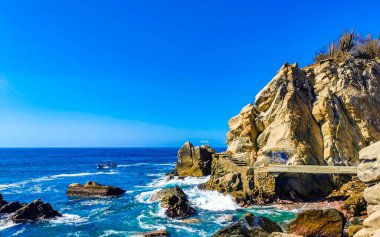 Mavi turkuaz su ve son derece güzel büyük sörfçü kayalıkları kayalar dağlar ve kayalar Zicatela Puerto Escondido Oaxaca 'daki plajlar.