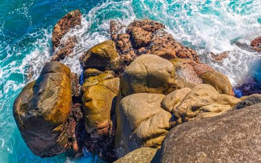 Mavi turkuaz su ve son derece güzel büyük sörfçü kayalıkları kayalar dağlar ve kayalar Zicatela Puerto Escondido Oaxaca 'daki plajlar.