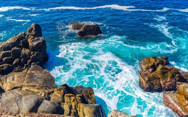 Mavi turkuaz su ve son derece güzel büyük sörfçü kayalıkları kayalar dağlar ve kayalar Zicatela Puerto Escondido Oaxaca 'daki plajlar.