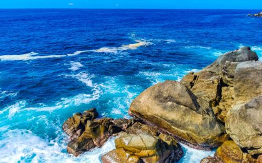 Mavi turkuaz su ve son derece güzel büyük sörfçü kayalıkları kayalar dağlar ve kayalar Zicatela Puerto Escondido Oaxaca 'daki plajlar.