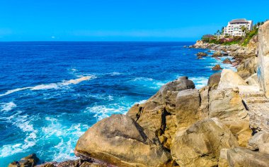 Mavi turkuaz su ve son derece güzel büyük sörfçü kayalıkları kayalar dağlar ve kayalar Zicatela Puerto Escondido Oaxaca 'daki plajlar.