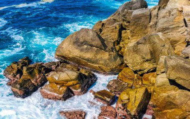 Mavi turkuaz su ve son derece güzel büyük sörfçü kayalıkları kayalar dağlar ve kayalar Zicatela Puerto Escondido Oaxaca 'daki plajlar.