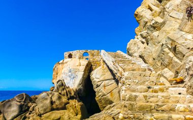 Mavi turkuaz su ve son derece güzel büyük sörfçü kayalıkları kayalar dağlar ve kayalar Zicatela Puerto Escondido Oaxaca 'daki plajlar.