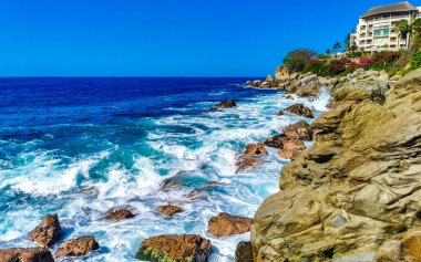 Mavi turkuaz su ve son derece güzel büyük sörfçü kayalıkları kayalar dağlar ve kayalar Zicatela Puerto Escondido Oaxaca 'daki plajlar.
