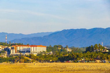 Puerto Escondido Oaxaca Meksika 16. Kasım 2022 'de güneş kumsalı insanları sörf yapıyor Palmiye ağaçları, plaj barı ve Zicatela Puerto Escondido Oaxaca' da mavi su dalgaları..